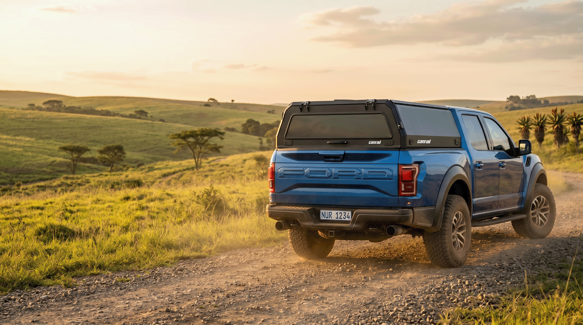 Black double-cab bakkie fitted with a Canrail canopy on a dusty South African farm road at sunset